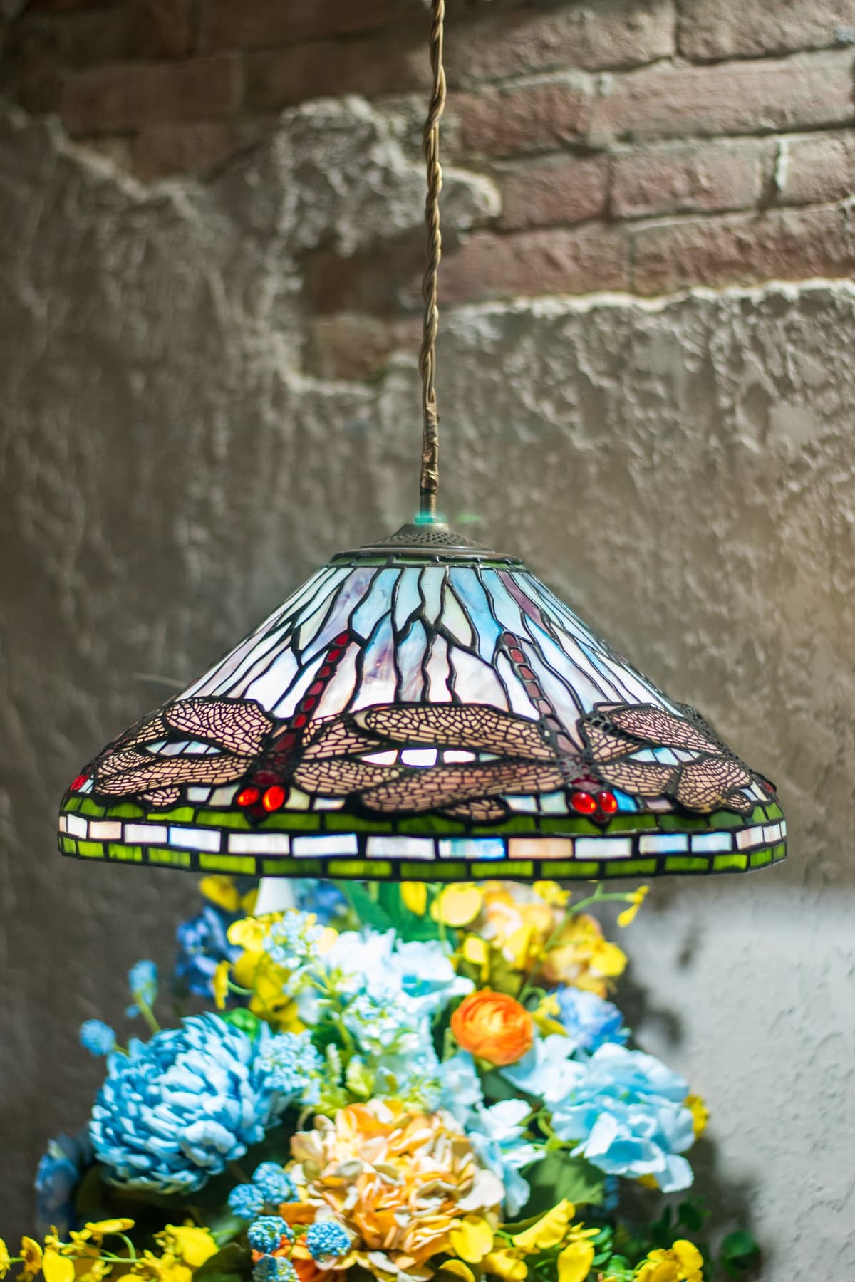 L&aacute;mpara de vitral sobre un arreglo de flores en Bella Nonna