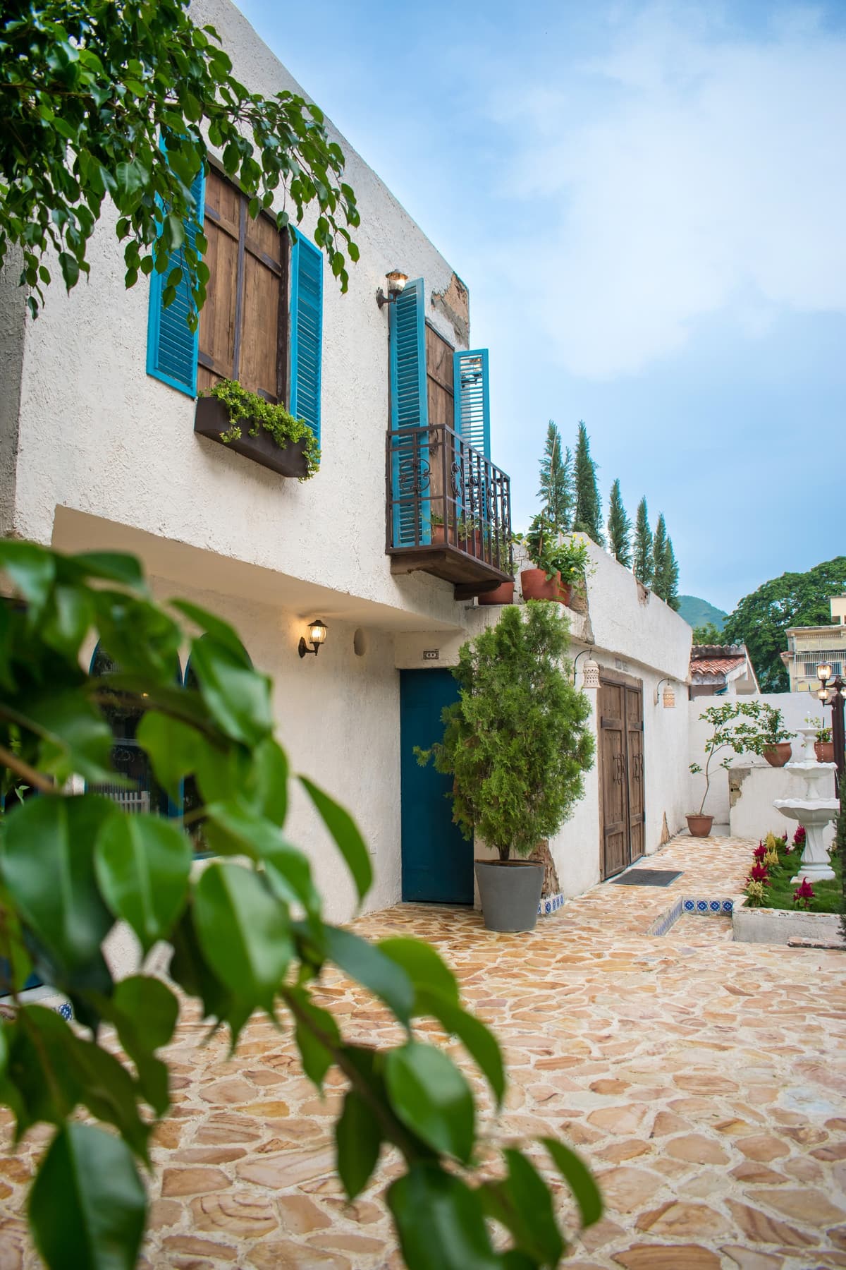 Pasillo mediterráneo con balcones azules y plantas en Bella Nonna, El Trigal